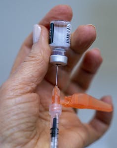 Une main qui prépare une dose de vaccin